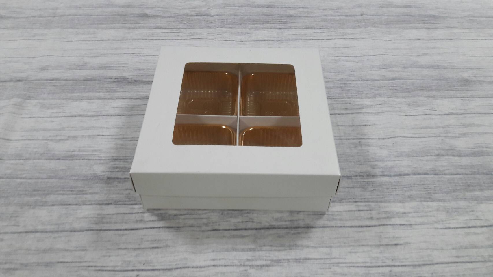 กล่องฝาครอบ กล่องของขวัญ กล่องเอนกประสงค์ กล่องแบบมีฝาครอบ สีขาว ขนาด 17.5 x 17.5 x 6.0 ซม.(มีหน้าต่างพลาสติก) พร้อมฐานตัวกั้นสินค้าแบบ 4 ช่อง ราคา 550 บาท ต่อแพ็ค (20 ใบ)