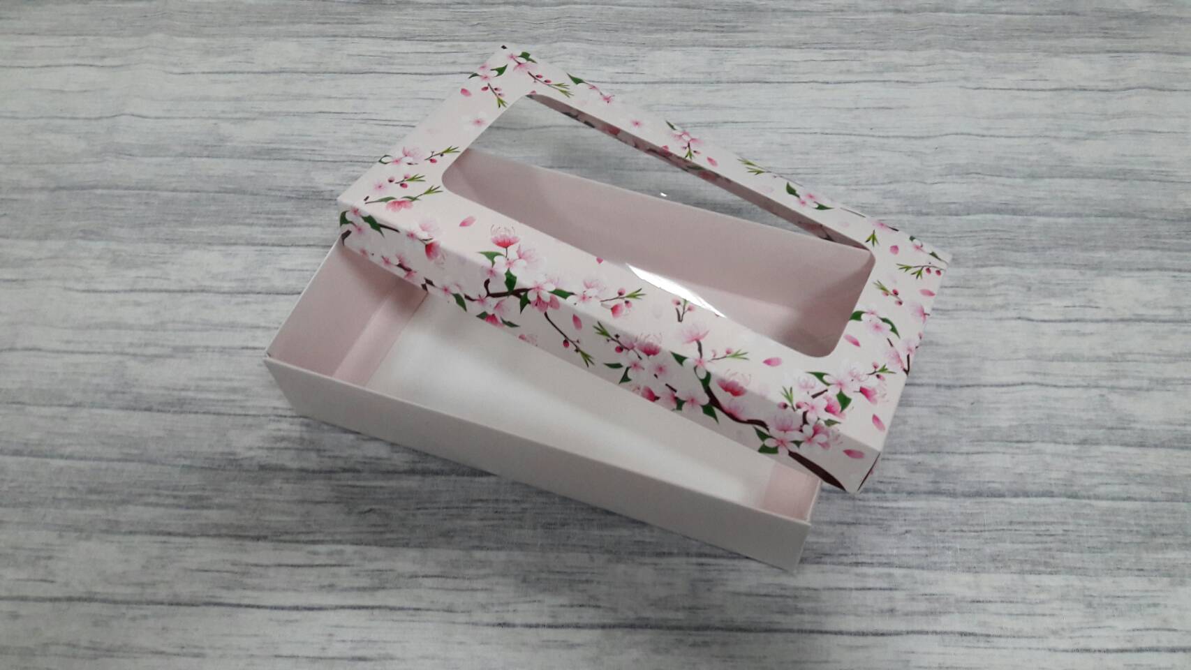 กล่องฝาครอบ ลายดอกไม้พื้นสีชมพูอ่อน 22*12.5*5 ซม.แบบมีหน้าต่างพลาสติก ราคา 380 บาท ต่อแพ็ค (20 ใบ)