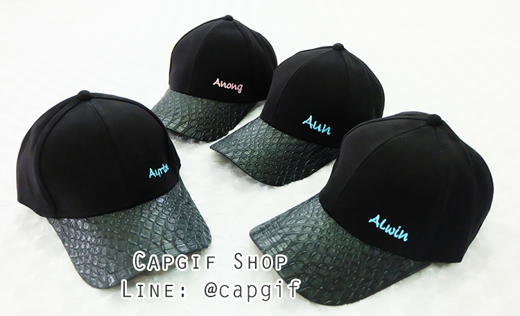หมวกแก๊ปสีดำปีกลายหนังงูปักชื่อทีมมุมล่างซ้าย