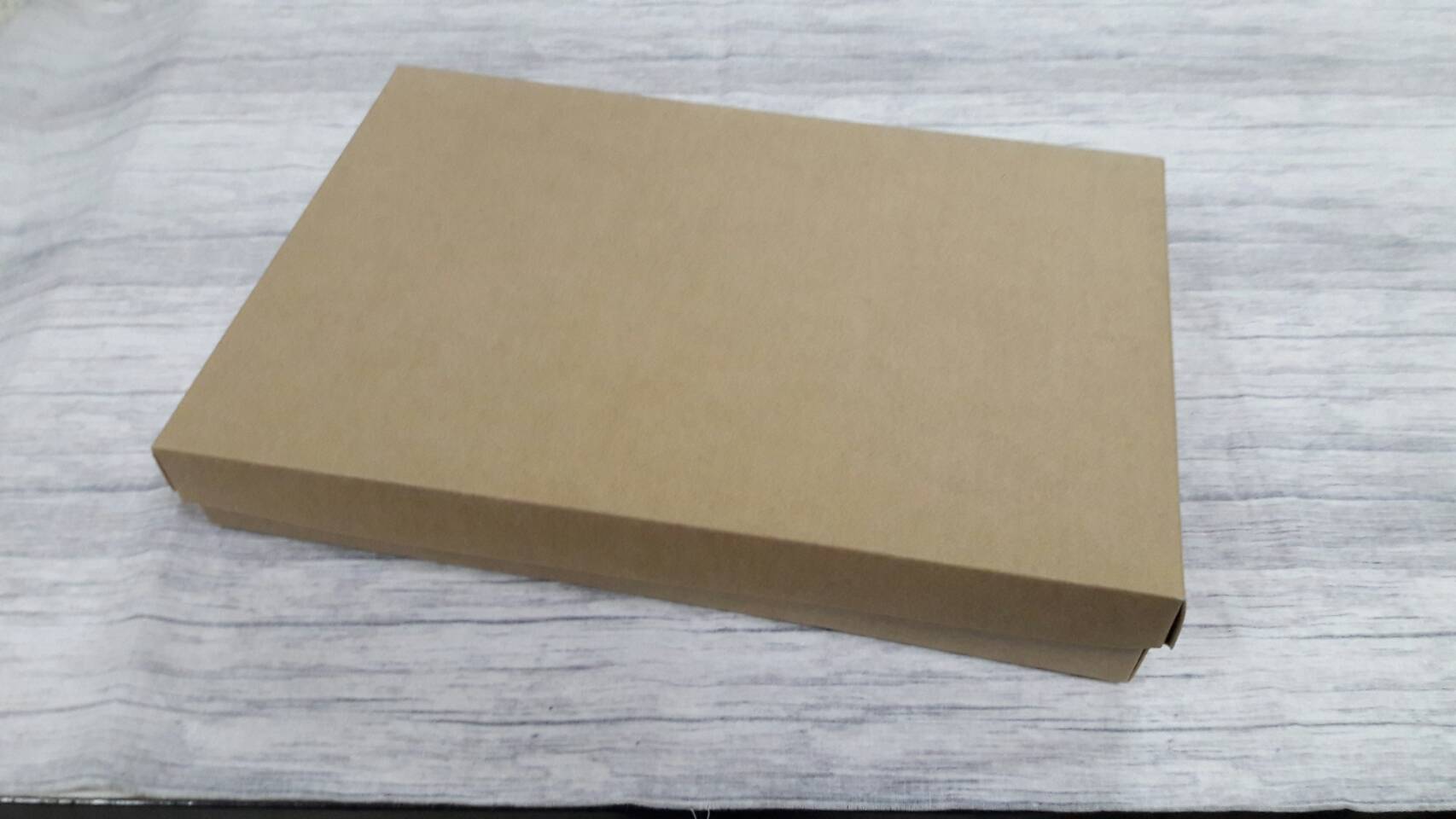 กล่องอเนกประสงค์ กล่องฝาครอบ กล่องของที่ระลึก กล่องของขวัญ กล่องใส่ผ้าไหม กล่องใส่กางเกงยีนส์ สีคราฟท์น้ำตาล ขนาด 23 x 35 x 5 ซม.ราคา 625 บาทต่อแพ็ค (20 ใบ)