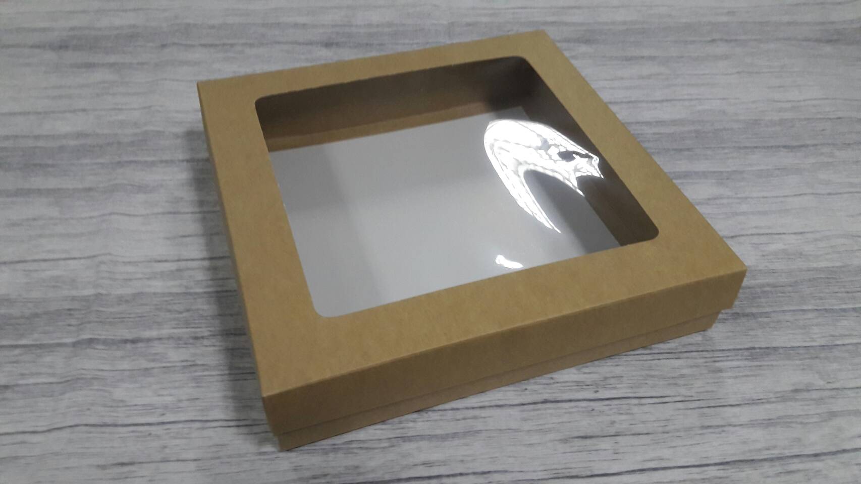 กล่องของขวัญ กล่องแบบมีฝาครอบ กล่องอเนกประสงค์ ขนาด 24 * 24 * 5 ซม. สีคราฟท์น้ำตาลอ่อน แบบมีหน้าต่างพลาสติก ราคา 580 บาท ต่อแพ็ค (20 ใบ)