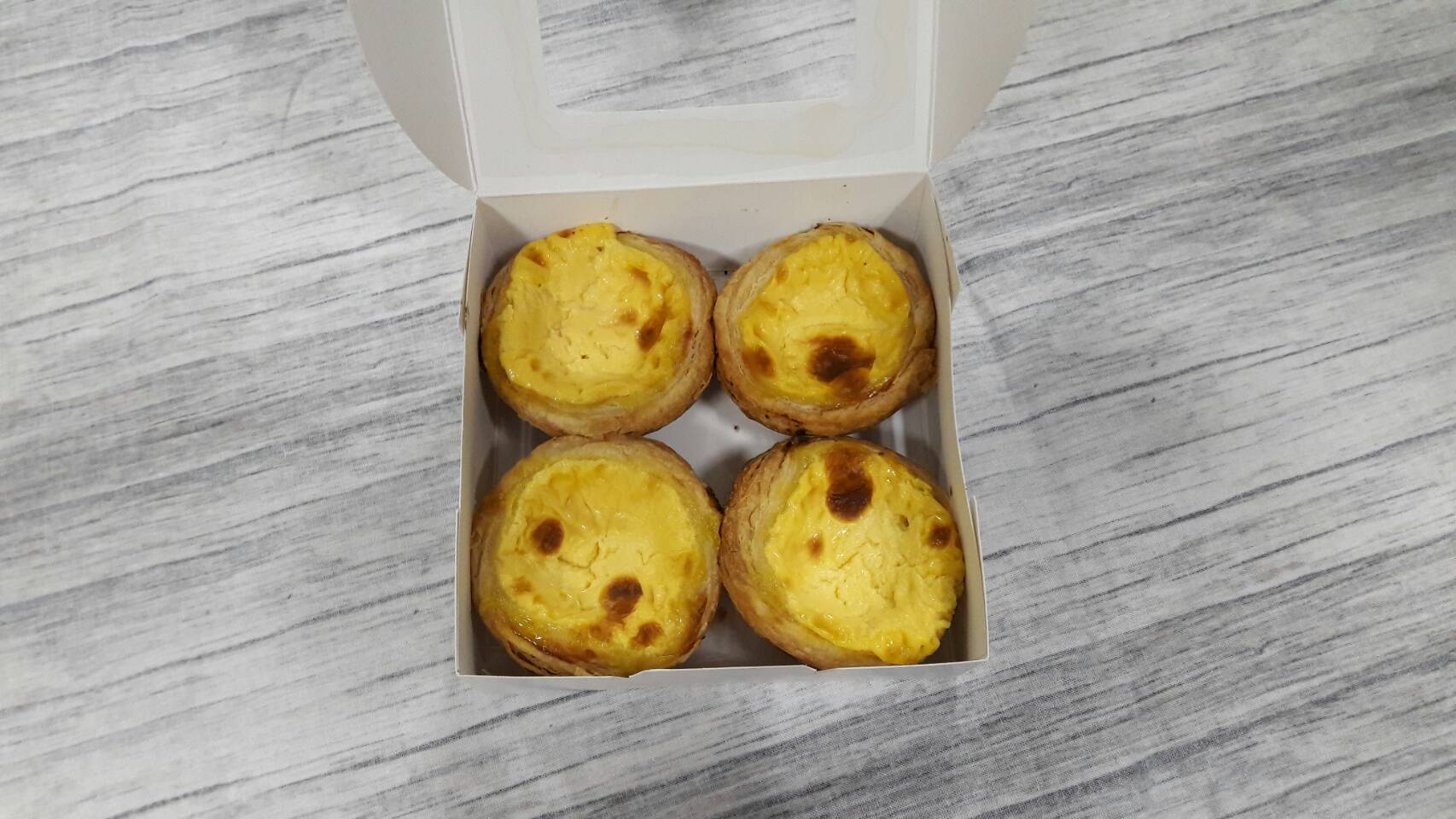 กล่องทาร์ต 4 ชิ้น (ขนาดถ้วยทาร์ต 6 ซม.) กล่องทรงแบน (หน้าต่างพลาสติก) ขนาด12.5x12.5x4.0ซม. สีขาว ราคา 100 บาทต่อแพ็ค (20 ใบ)