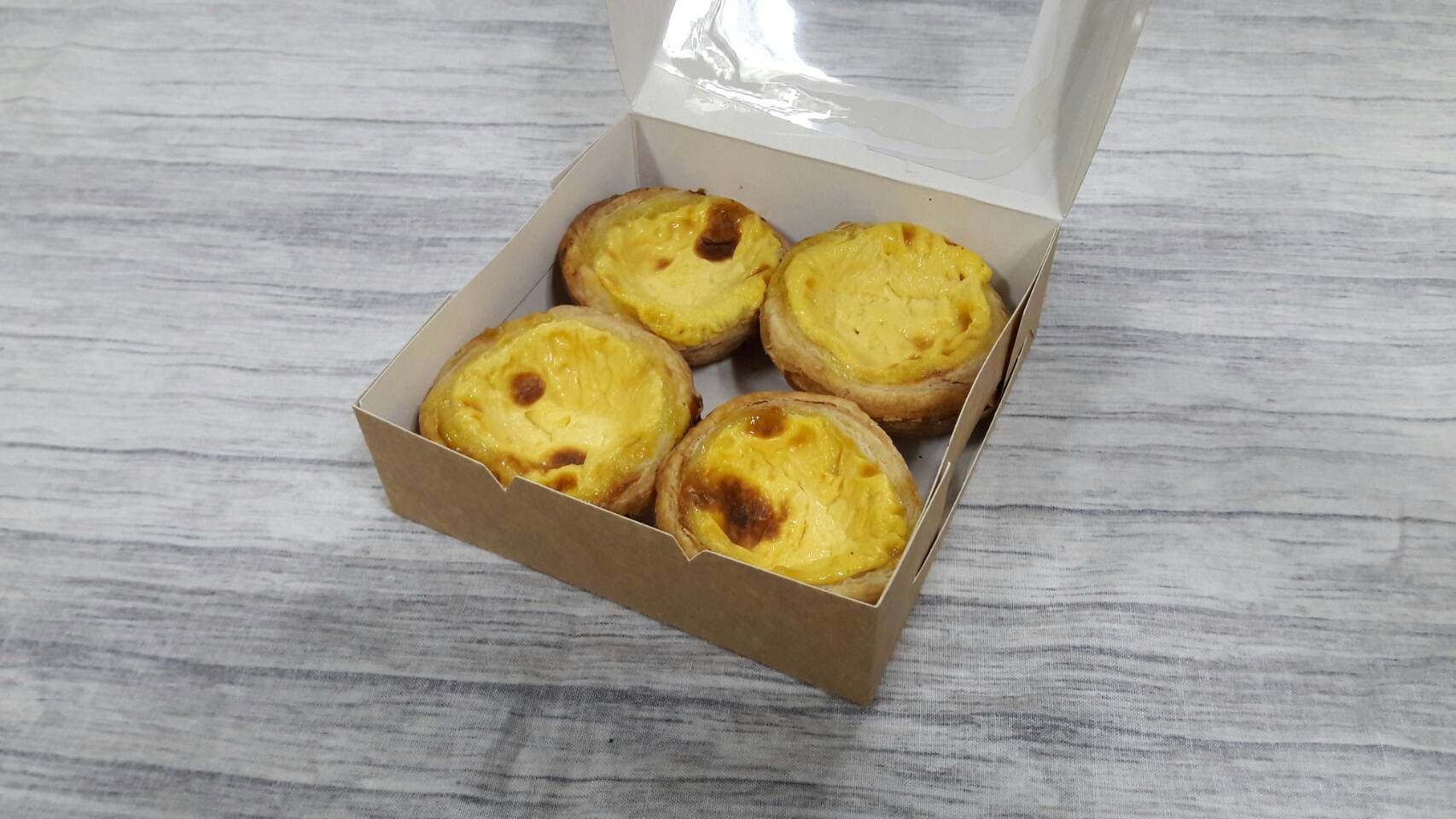 กล่องทาร์ต 4 ชิ้น (ขนาดถ้วยทาร์ต 6 ซม.) กล่องทรงแบน (ฝาทึบ) ขนาด 12.5x12.5x4.0ซม. สีคราฟท์น้ำตาลอ่อน ราคา 100 บาทต่อแพ็ค (20 ใบ)