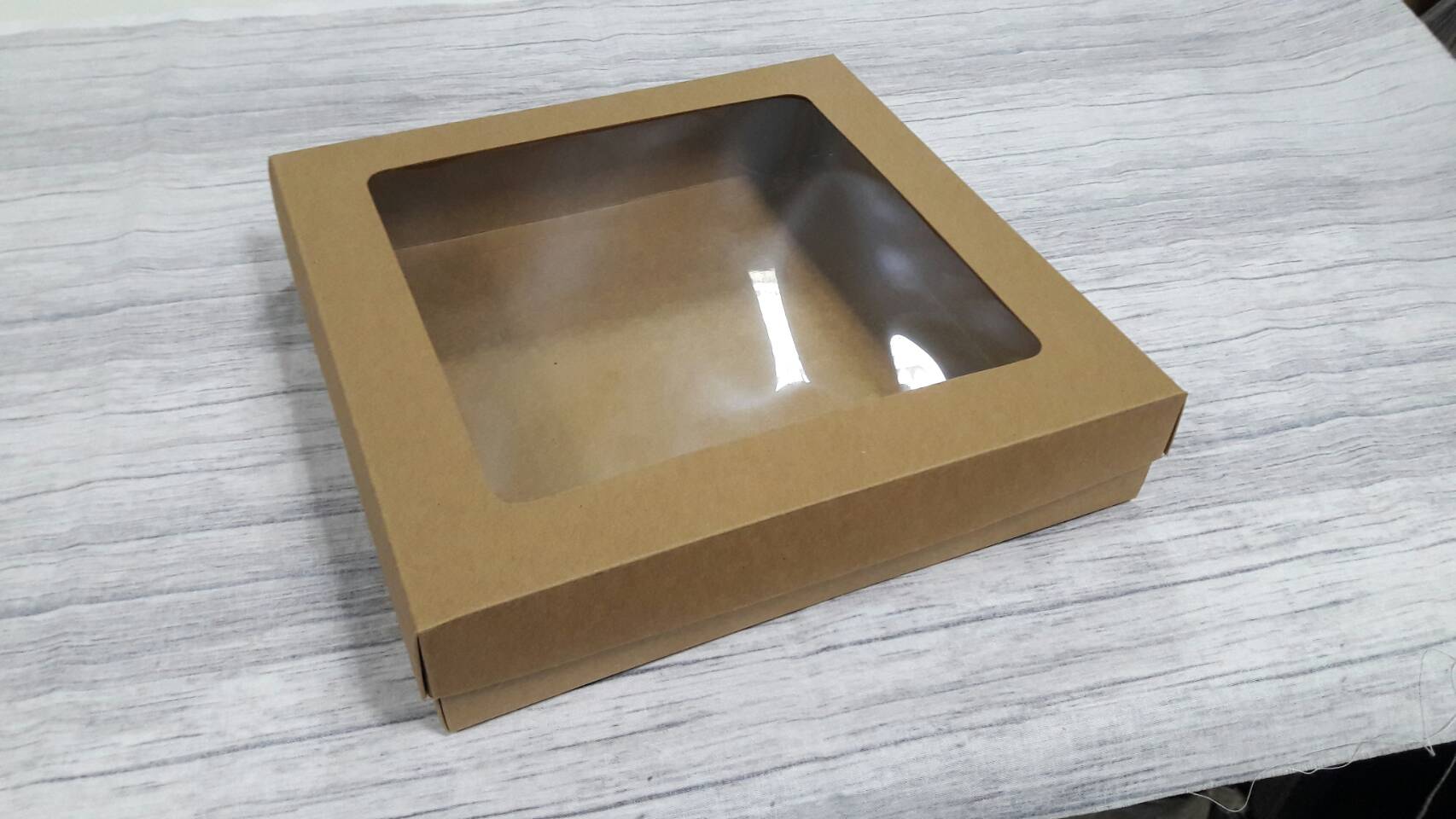 กล่องของขวัญ กล่องแบบมีฝาครอบ กล่องอเนกประสงค์ ขนาด 24 * 24 * 5 ซม. สีคราฟท์น้ำตาลเข้ม แบบมีหน้าต่างพลาสติก ราคา 580 บาท ต่อแพ็ค (20 ใบ)