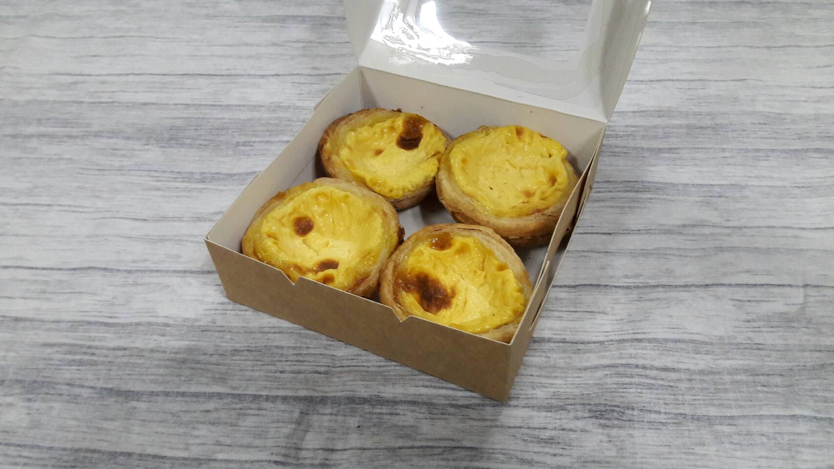 กล่องทาร์ต 4 ชิ้น (ขนาดถ้วยทาร์ต 6 ซม.) กล่องทรงแบน (หน้าต่างพลาสติก) ขนาด12.5x12.5x4.0ซม. คราฟท์น้ำตาลอ่อน ราคา 110 บาทต่อแพ็ค (20 ใบ)