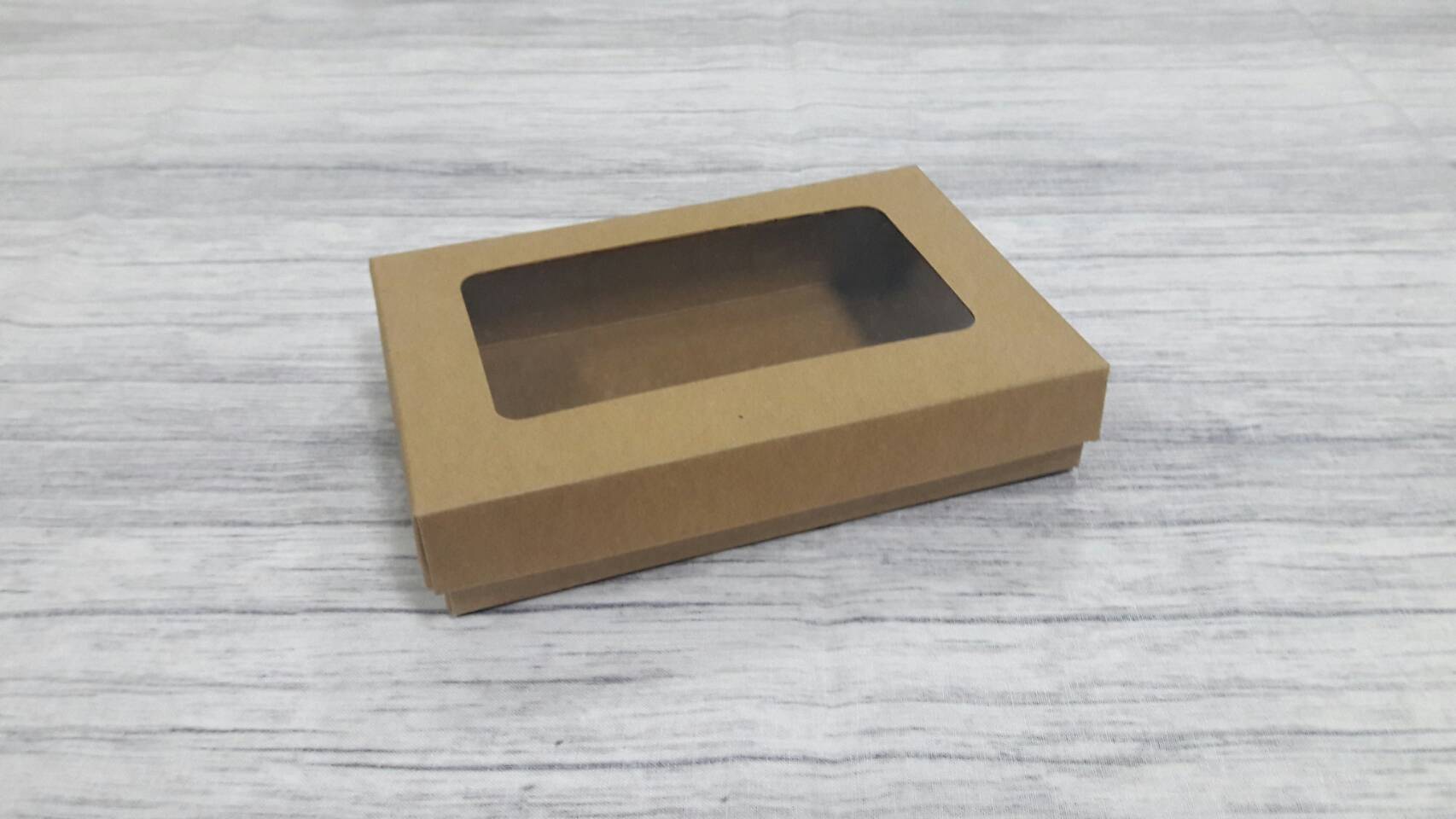 กล่องฝาครอบ กล่องของขวัญ กล่องแบบมีฝาครอบ กล่องอเนกประสงค์ ขนาด 10 x 15 x 3 ซม.สีคราฟท์น้ำตาลเข้ม แบบมีหน้าต่างพลาสติก ราคา 285 บาท ต่อแพ็ค (20 ใบ)