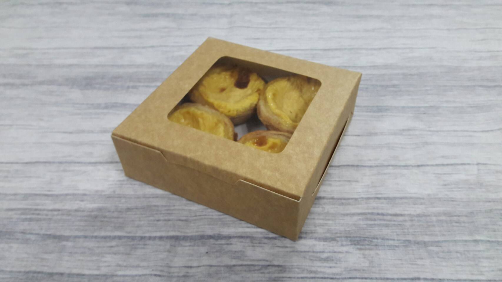 กล่องทาร์ต 4 ชิ้น (ขนาดถ้วยทาร์ต 6 ซม.) กล่องทรงแบน (หน้าต่างพลาสติก) ขนาด12.5x12.5x4.0ซม. คราฟท์น้ำตาลอ่อน ราคา 110 บาทต่อแพ็ค (20 ใบ)