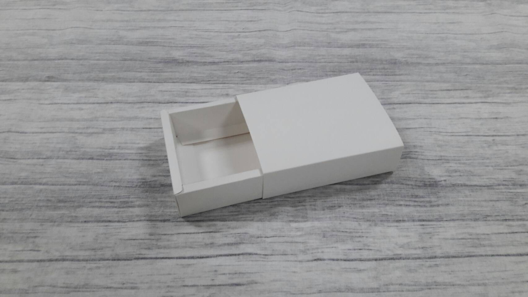 กล่องสไลด์ กล่องของขวัญ กล่องของที่ระลึก กล่องอเนกประสงค์ กล่องสบู่ กล่องขนม กล่องแบบฝาสไลด์ สีขาว ขนาด 8.2x10.2x2.7 ซม. ราคา 170 บาท (20 ใบ ต่อแพ็ค)